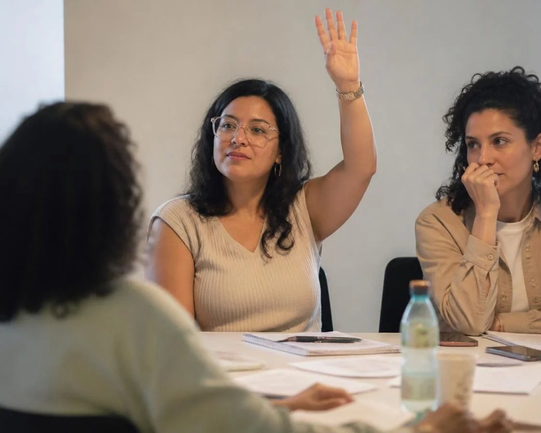 Roda de participantes; um deles repete em voz alta o argumento do colega antes de apresentar a réplica