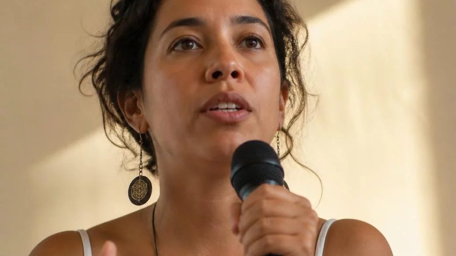 Duas participantes sentadas frente a frente numa mesa da sala do Fortaleza; a da direita rascunha a resposta que vai dar
